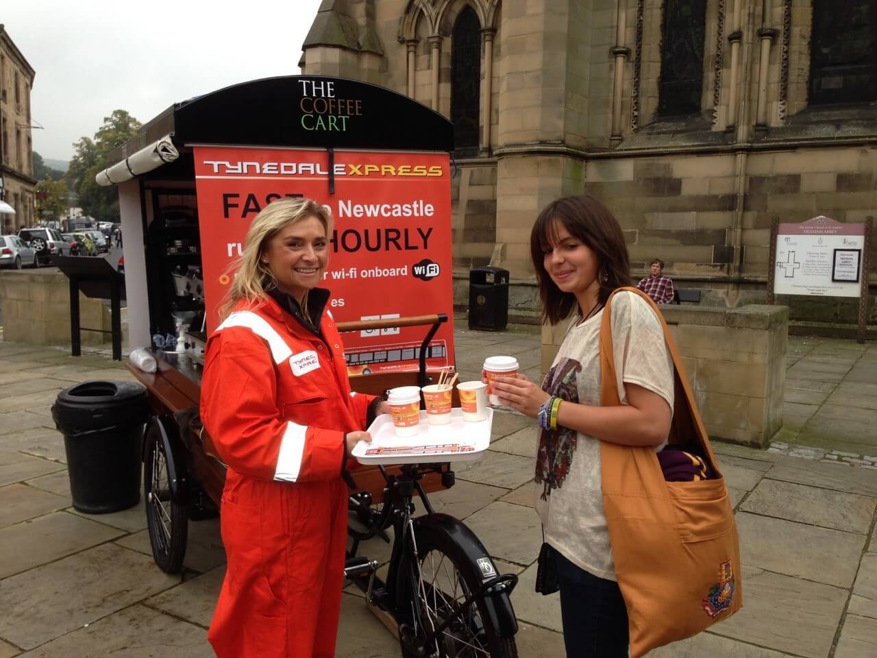 young woman getting a cup of coffee from the coffee cart