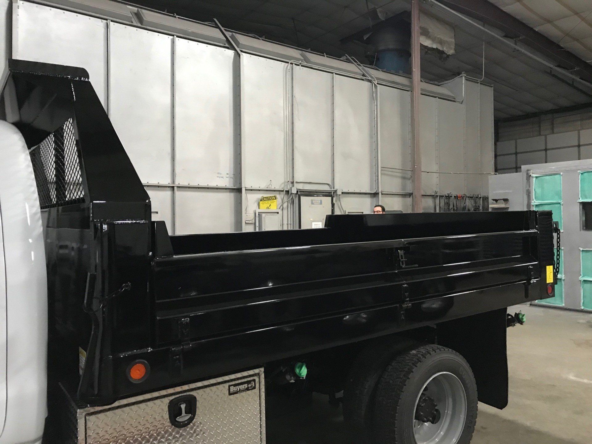 A black dump truck is parked in a warehouse