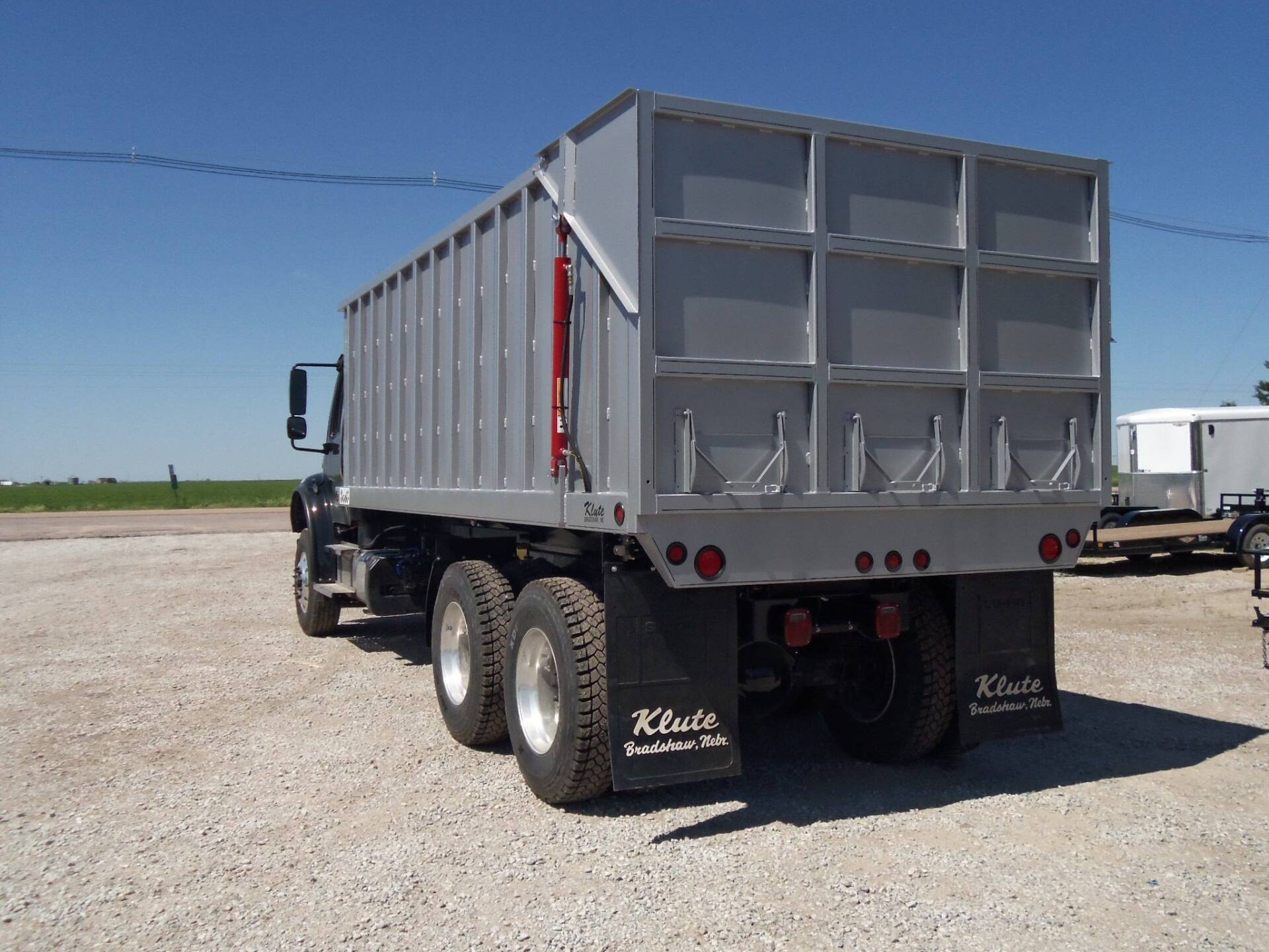 A kiste dump truck is parked in a gravel lot