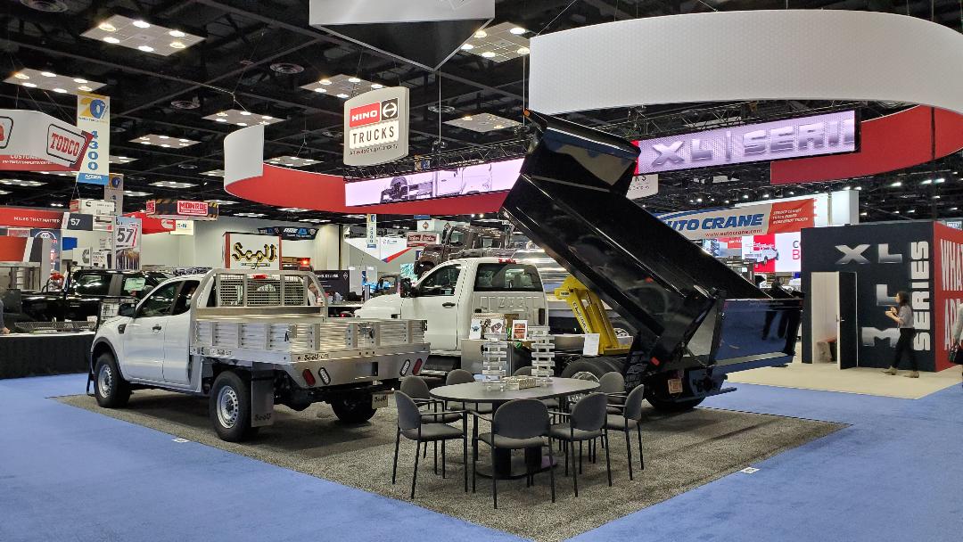 Two trucks are on display at a car show.