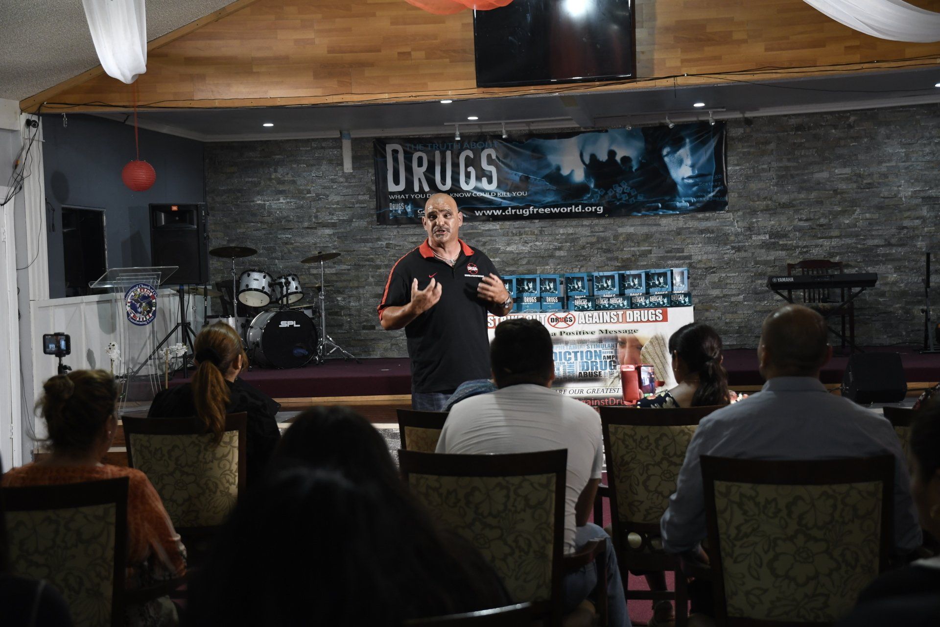 A man is giving a speech to a group of people in a room.