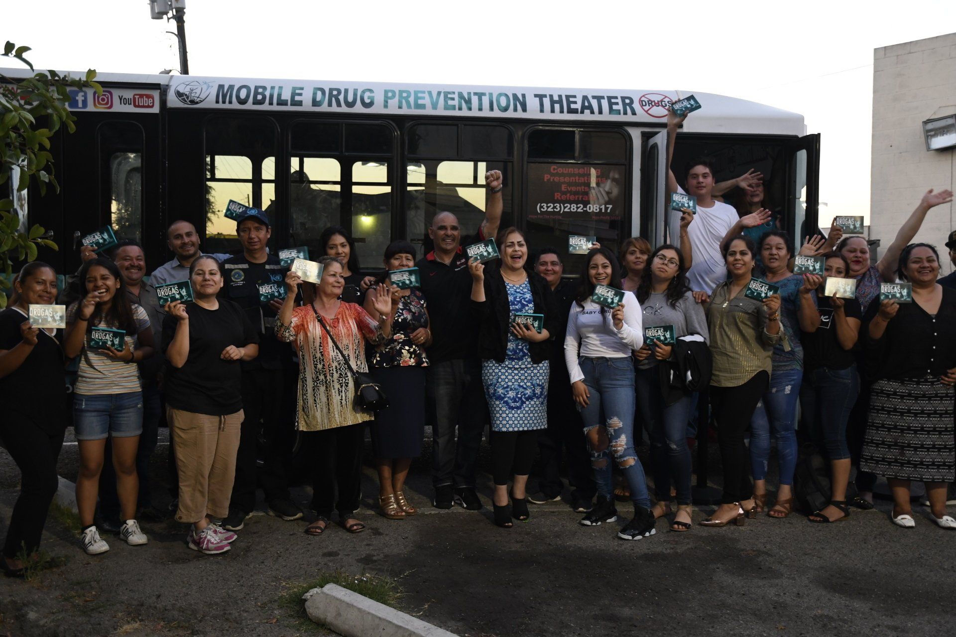 A group of people standing in front of a mobile drug prevention theater