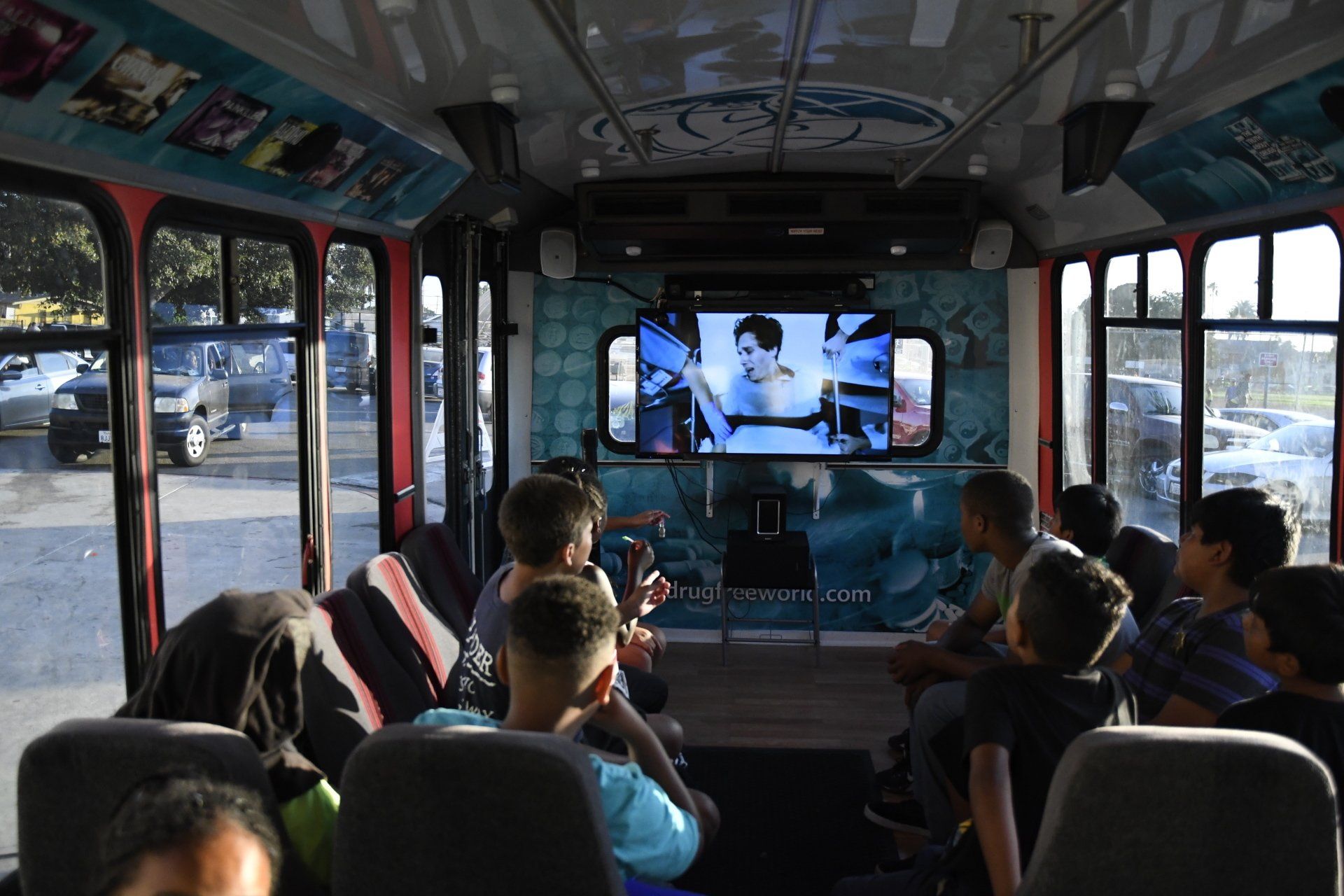 A group of people are sitting on a bus watching a movie