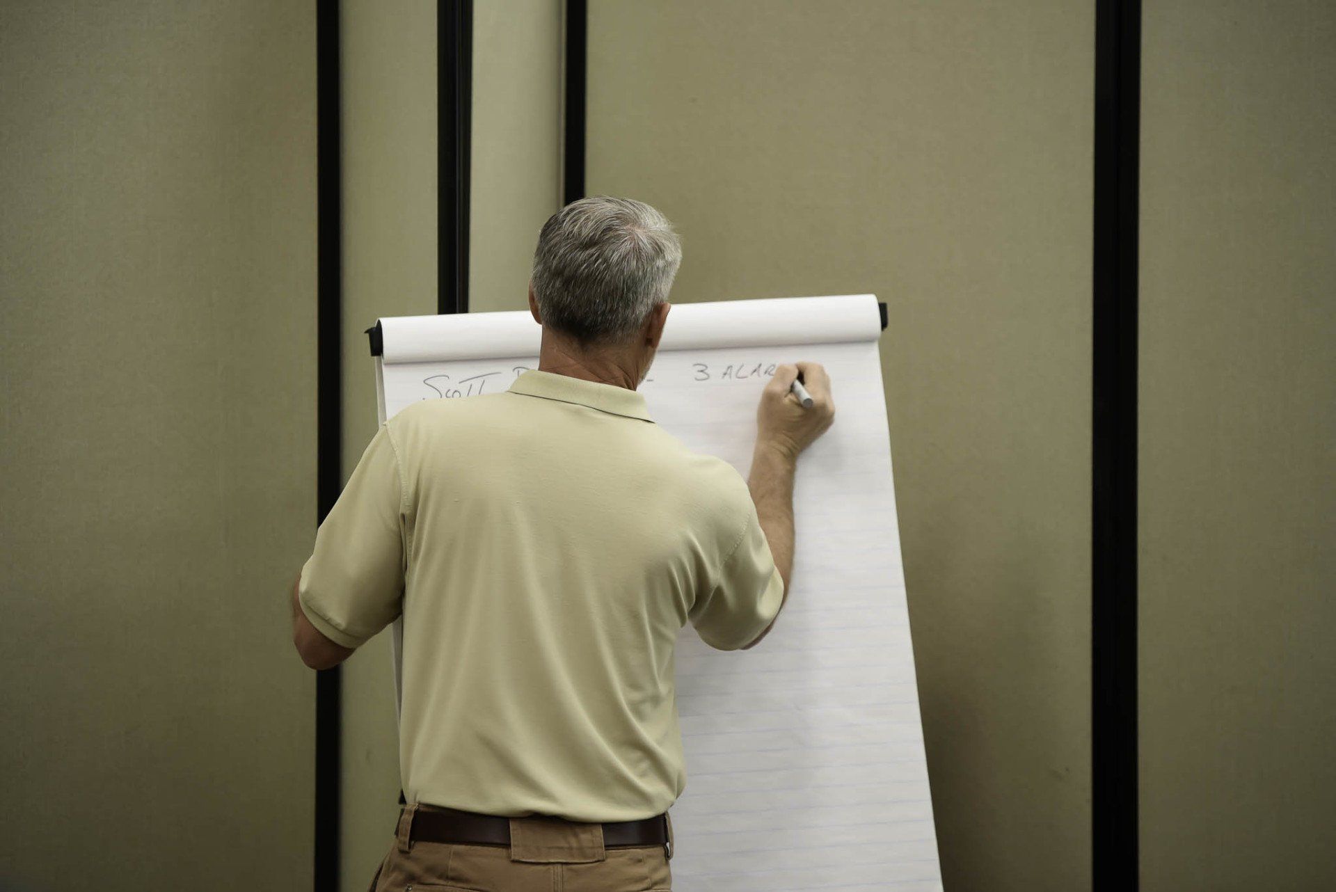 Man writing on a flip chart in a conference room