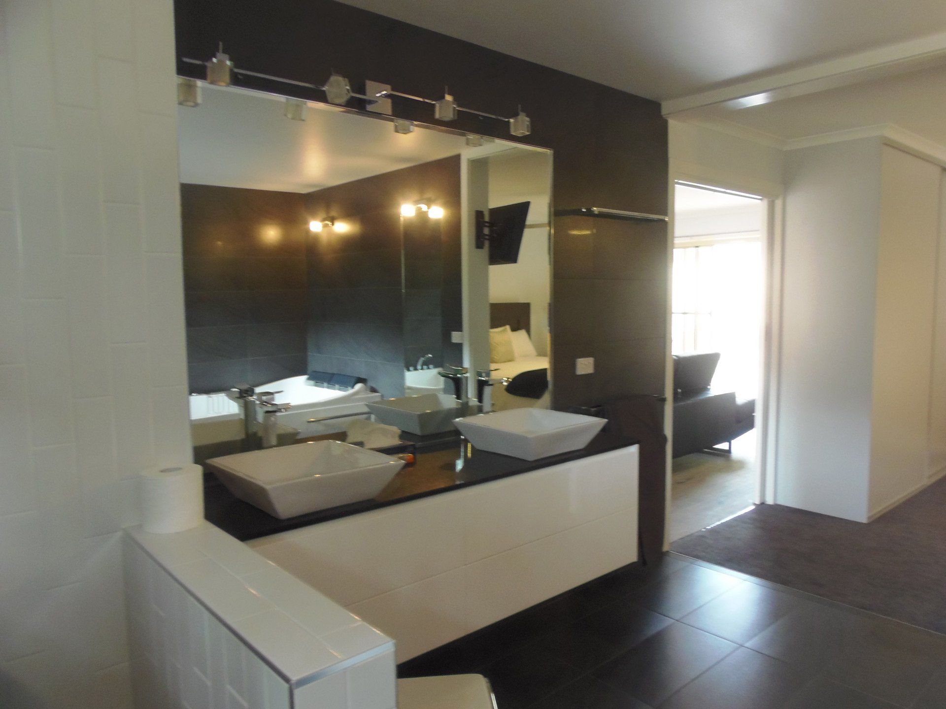 Main En-suite bathroom, featuring huge spa, walk-in shower, and make-up mirror. Hideaway Villa, Halls Gap Valley Lodges.