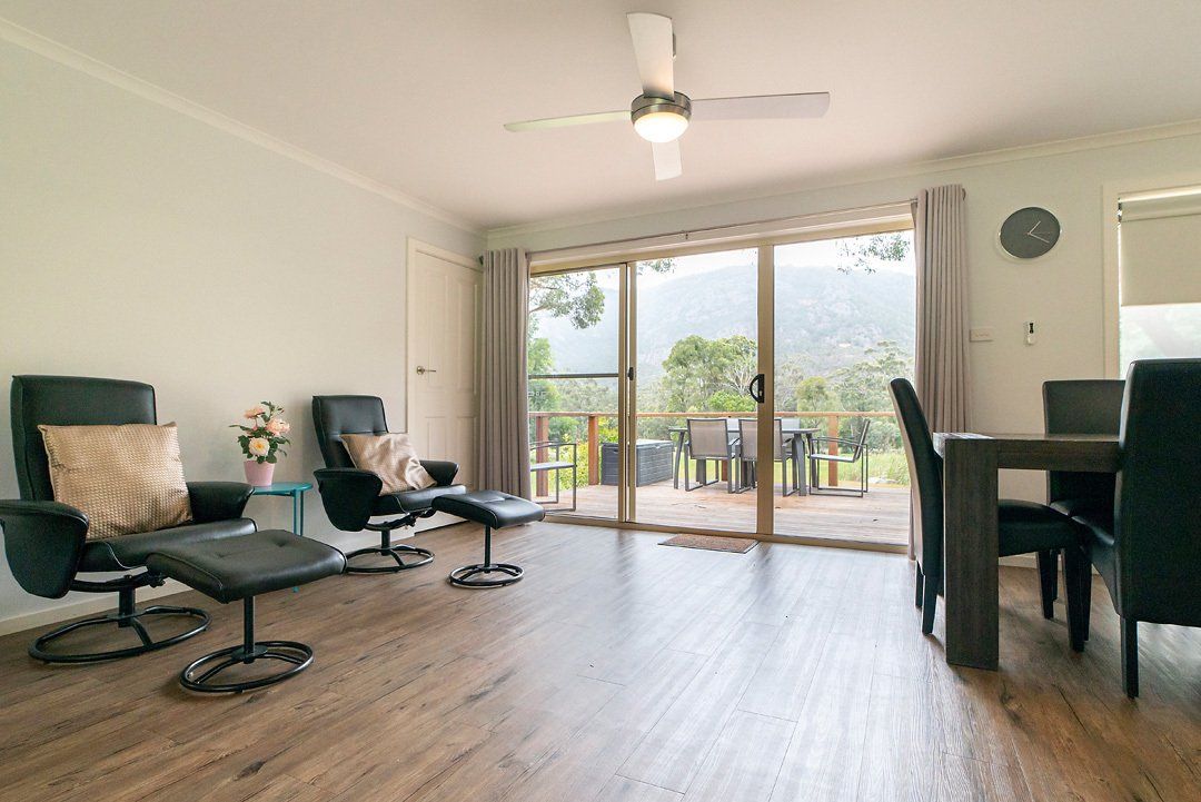 Entrance area looking out to front deck with dining area in foreground at Hideaway Villa, Halls Gap Valley Lodges.