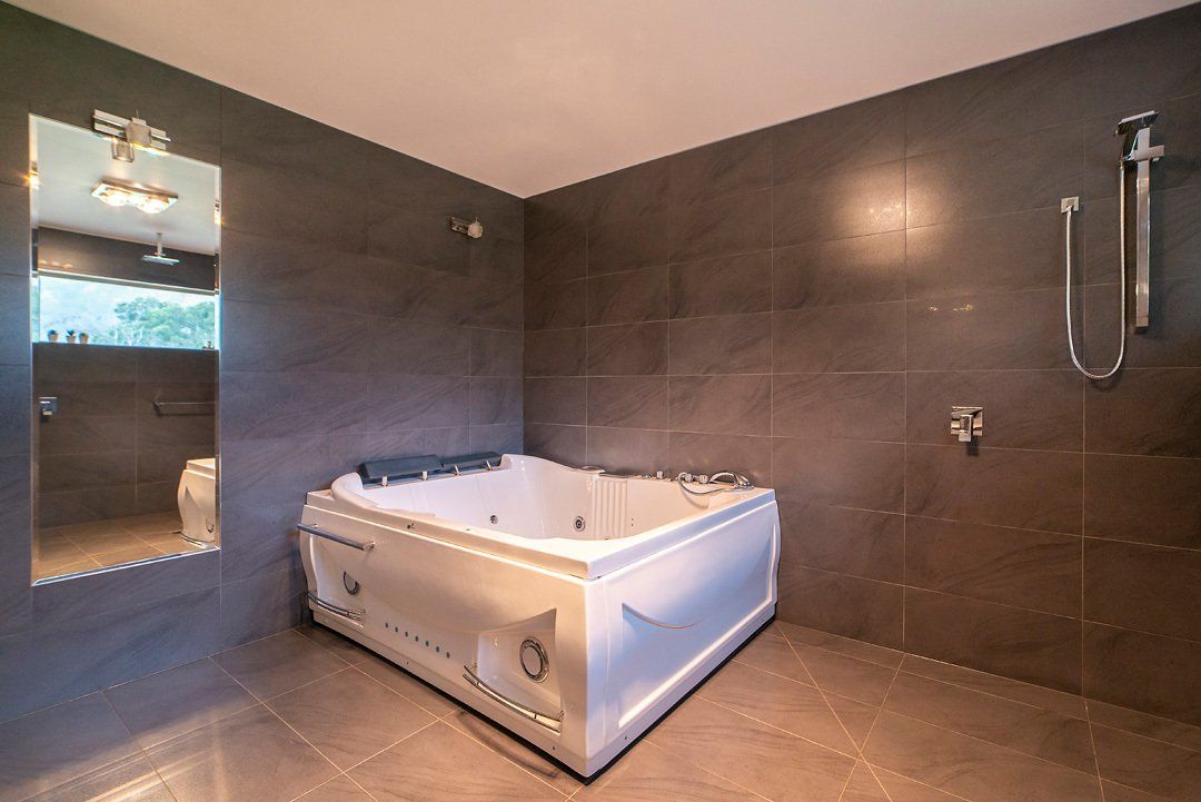 Main En-suite bathroom, featuring huge spa, walk-in shower, and make-up mirror. Hideaway Villa, Halls Gap Valley Lodges.
