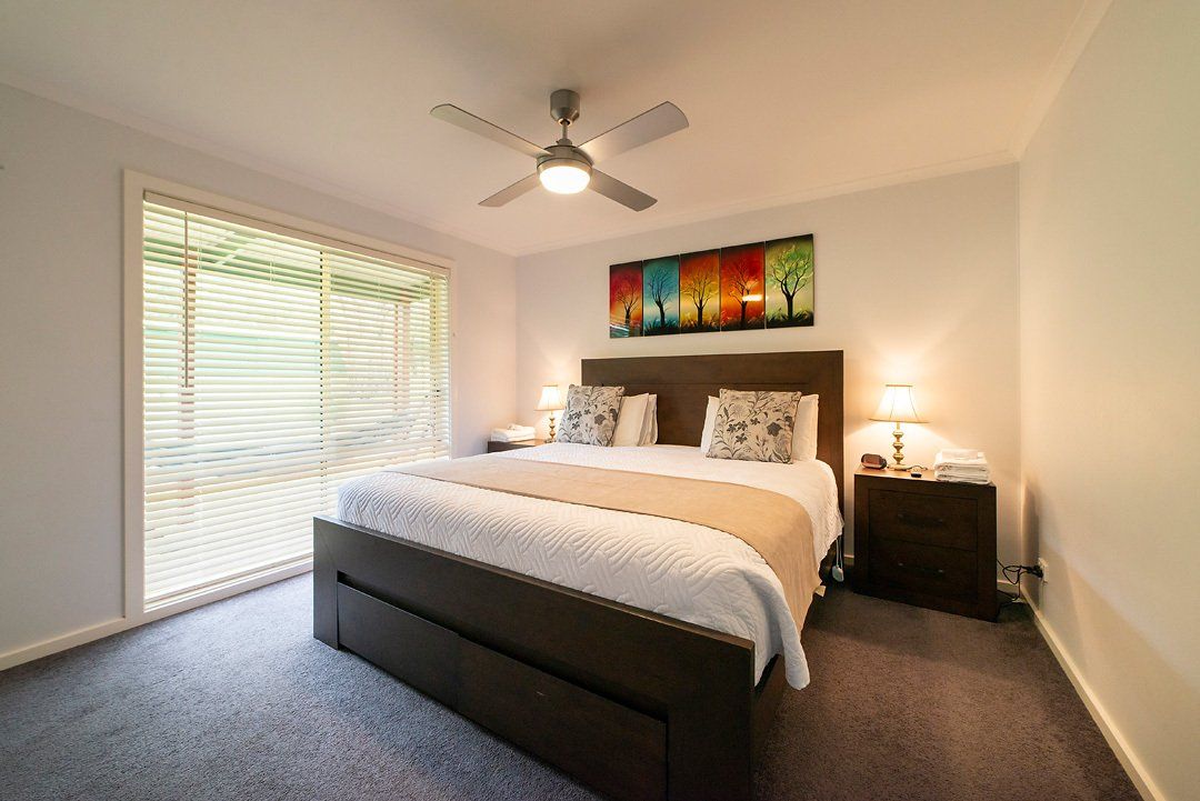 Main bedroom with luxurious King bed and en-suite bathroom at Hideaway Villa, Halls Gap Valley Lodges.