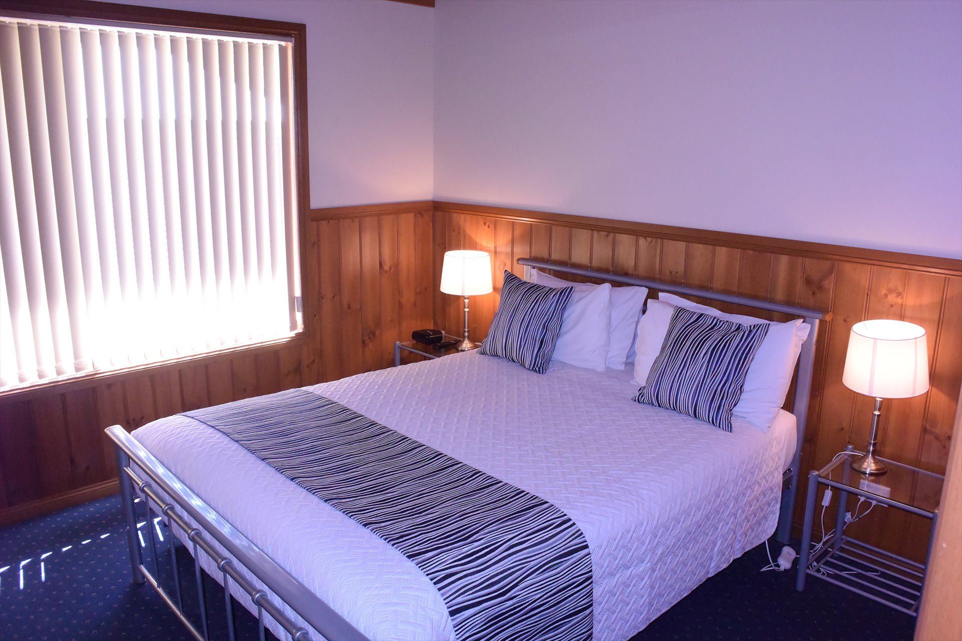 Spacious chalet-style lodges, bedroom with Queen bed at Halls Gap Valley Lodges in The Grampians, Victoria.