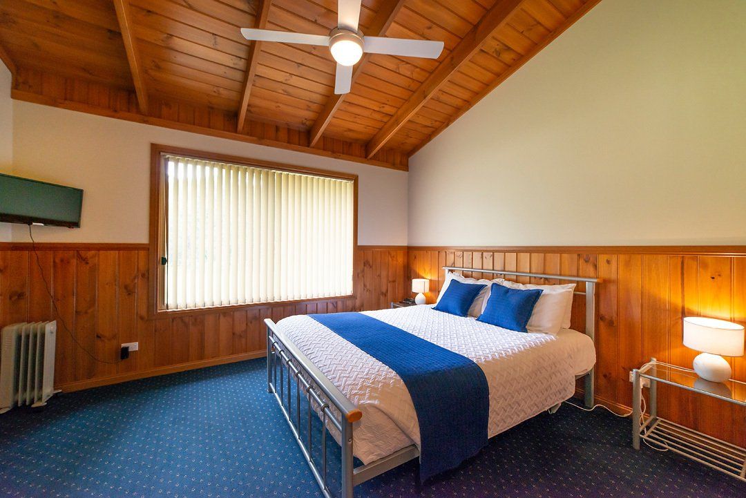 Comfortable, modern queen-size bed in a Halls Gap Valley chalet-style Lodge bedroom.