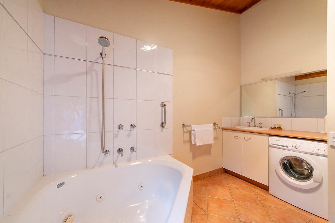 Bathroom including spa and washing machine in chalet-style self-contained Halls Gap Valley Lodges.