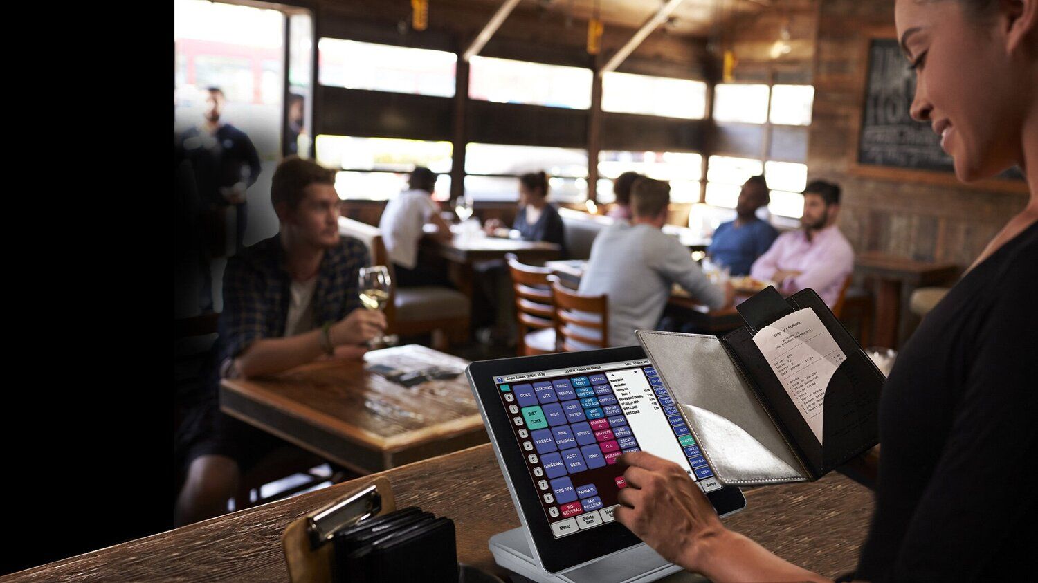 A woman is using a laptop computer in a restaurant.