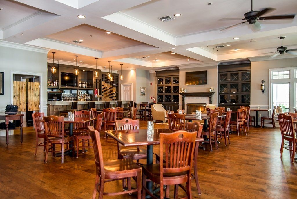 A large dining room with tables and chairs and a fireplace.