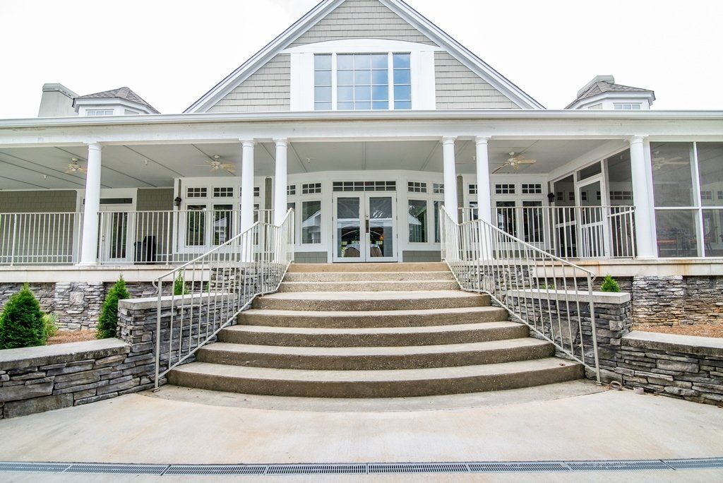 The front of a large house with stairs leading up to it.