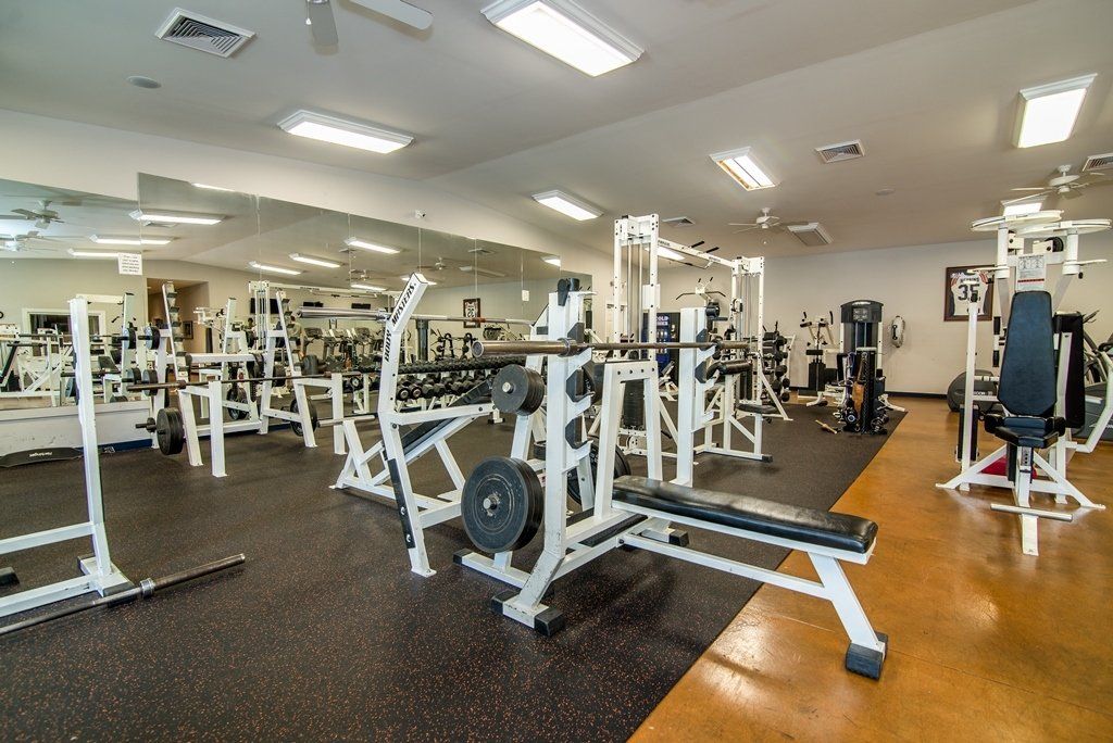 A large gym filled with lots of exercise equipment.