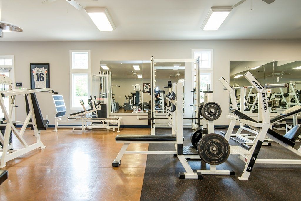 A large gym filled with lots of exercise equipment.