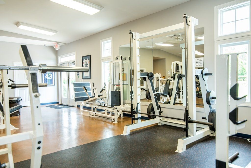 A gym filled with lots of exercise equipment and a mirror.
