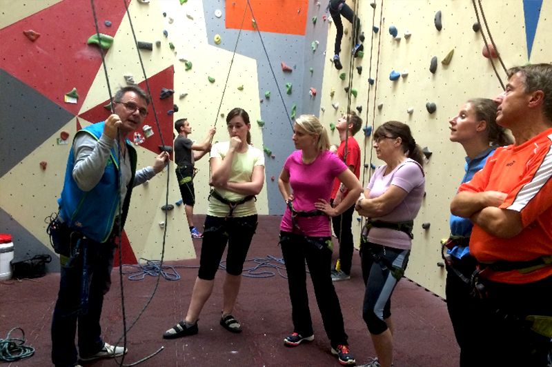 Eine Gruppe von Menschen steht vor einer Kletterwand