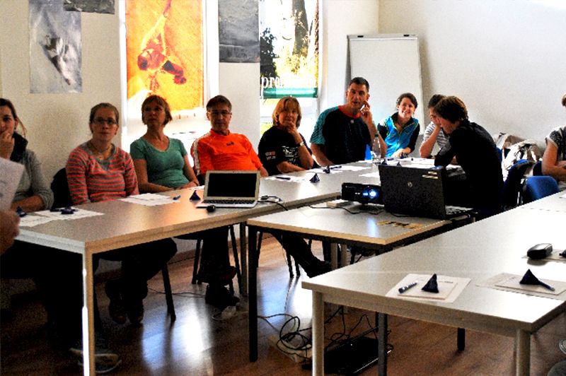 Eine Gruppe von Menschen sitzt mit Laptops an Tischen
