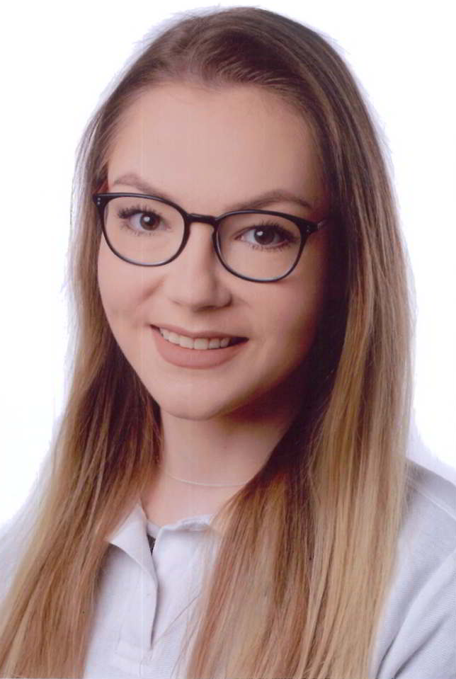Eine Frau mit Brille und weißem Hemd lächelt in die Kamera.
