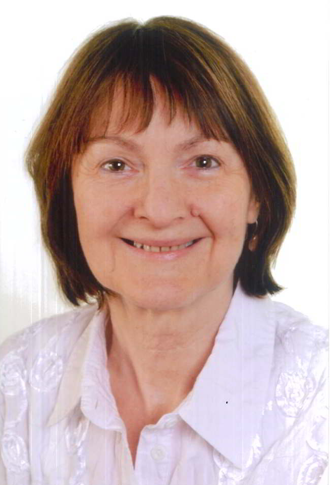 Eine Frau in einem weißen Hemd lächelt in die Kamera.