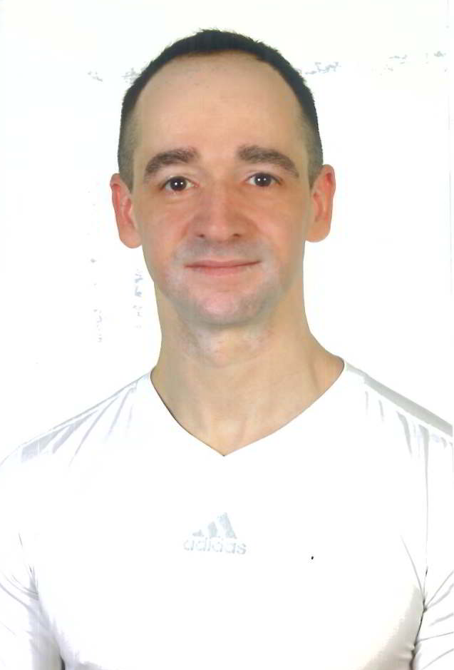 Ein Mann in einem weißen Adidas-Shirt lächelt in die Kamera