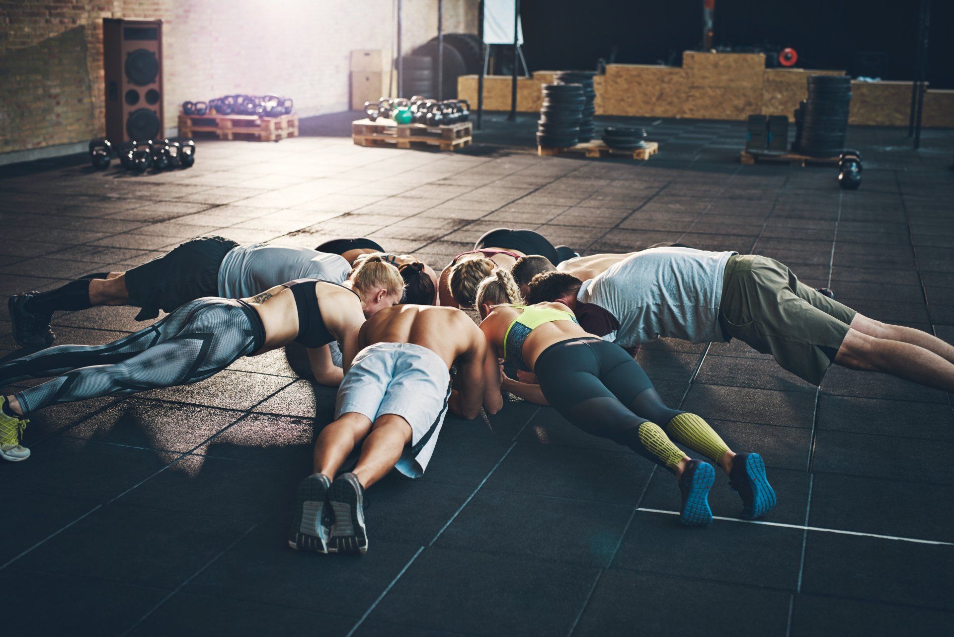 Eine Gruppe von Leuten macht in einem Fitnessstudio Liegestütze.