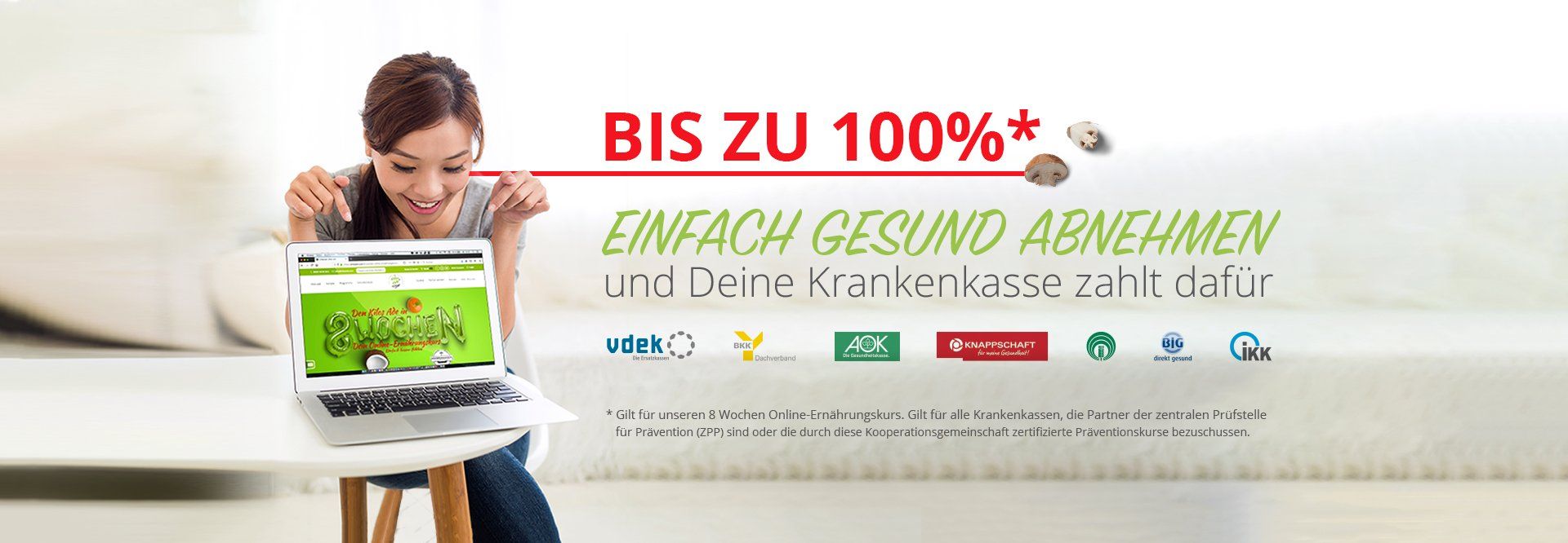 Eine Frau sitzt an einem Tisch und benutzt einen Laptop.