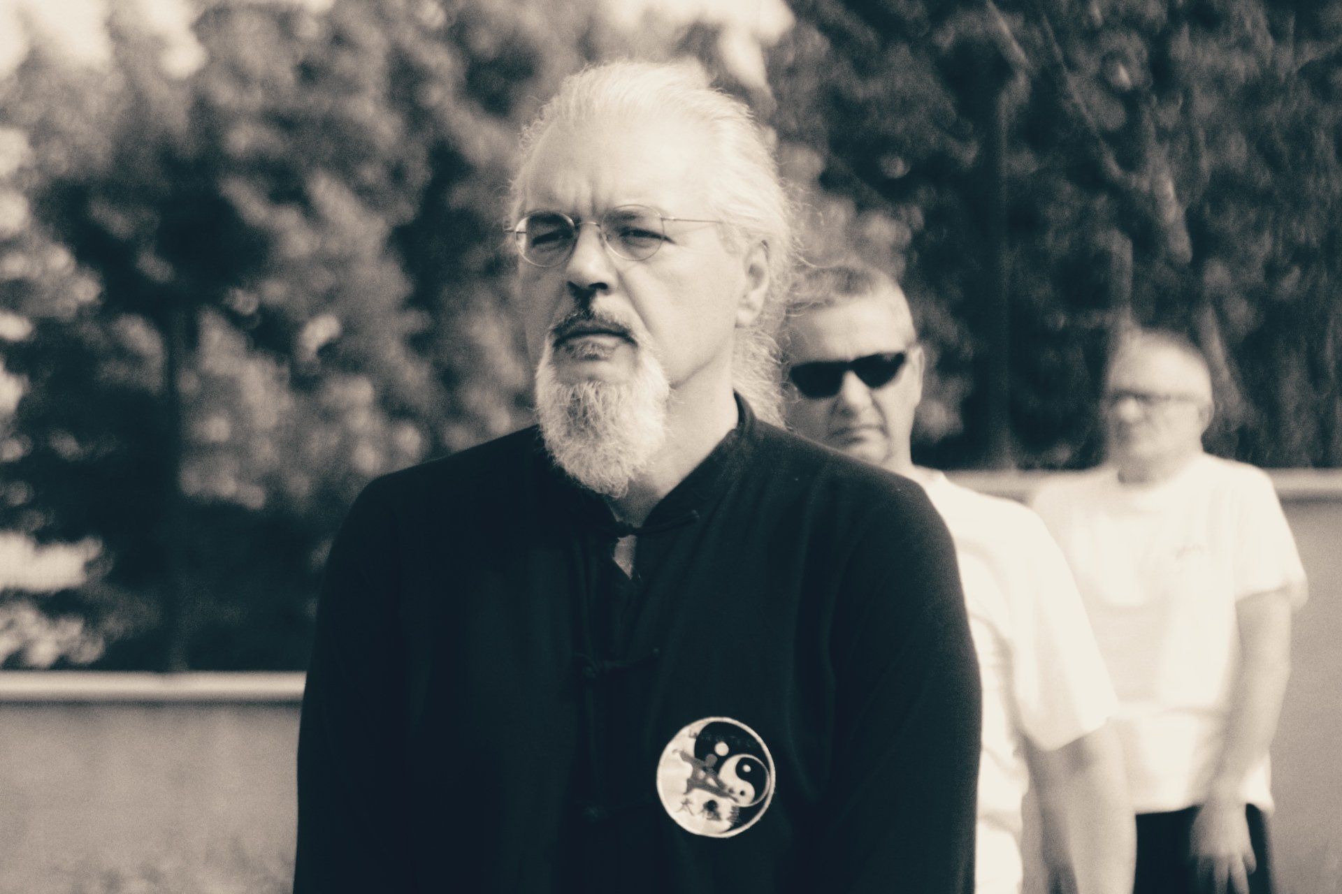 Un uomo con la barba è in fila con altri due uomini.