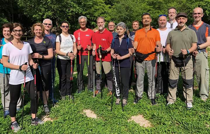 Un gruppo di persone è in piedi in un campo con in mano dei bastoncini da passeggio.