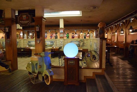 una Vespa, un tavolino con una lampada rotonda all’interno del ristorante