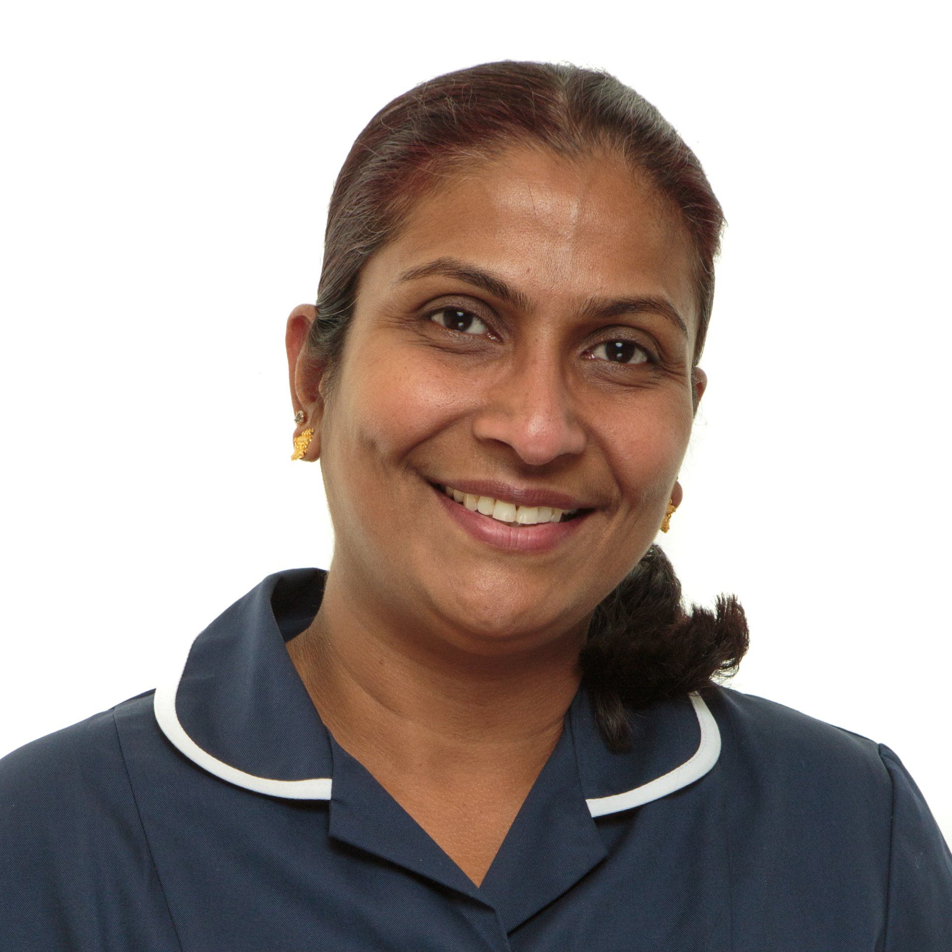Professional headshot of an Indian nurse wearing uniform, smiling and stood against a white background