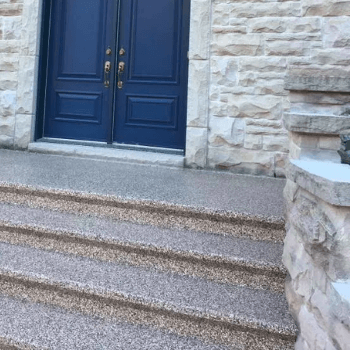 Blue double doors set into a stone building with stone steps leading up.