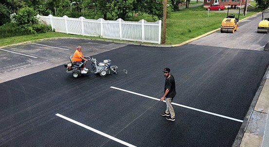 Applying Strip Line On Asphalt Pavement — Oilville, VA — Wells Paving & Seal Coating