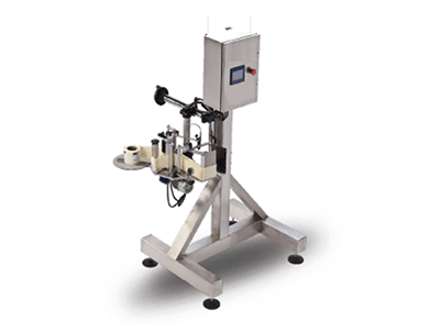 Máquina industrial sobre un soporte metálico con caja de control y bobinas montadas.