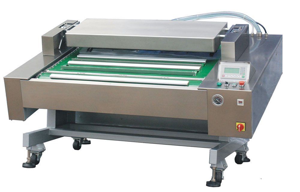 Máquina industrial de plataforma plana con rodillos transportadores verdes y carcasa metálica gris sobre ruedas.