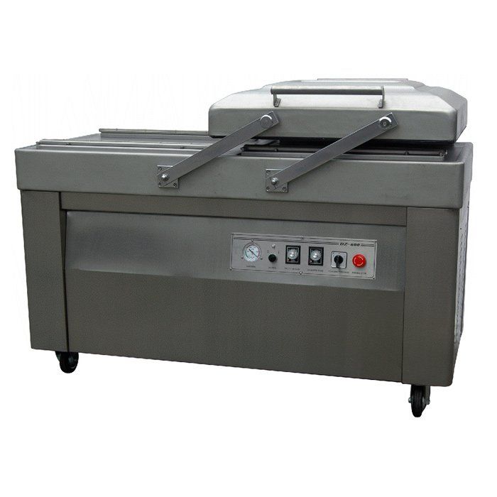 Máquina selladora al vacío de acero inoxidable con panel de control y dos brazos de sellado sobre ruedas.