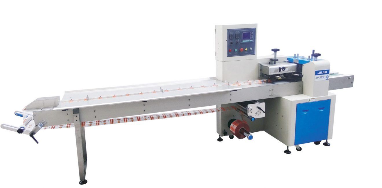 Máquina de embalaje con cinta transportadora larga, panel de control y armario lateral azul sobre fondo blanco.