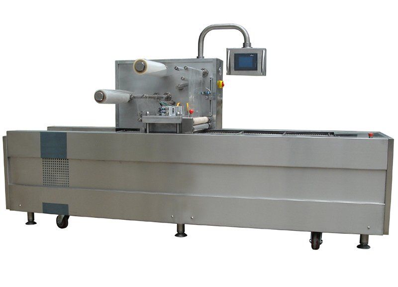 Máquina de embalaje industrial de acero inoxidable con panel de control táctil sobre una base con ruedas.