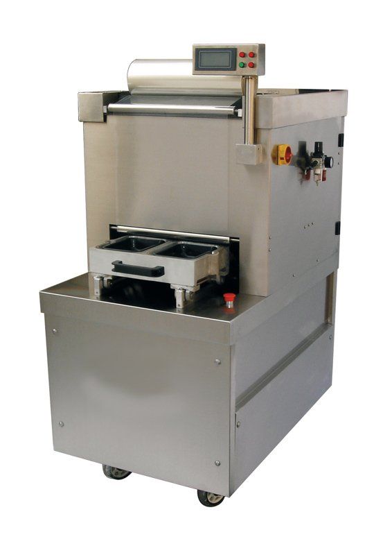 Máquina industrial de acero inoxidable con panel de control y bandeja frontal abierta sobre ruedas.