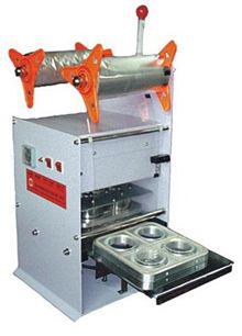 Máquina compacta de envasado de alimentos con rodillos naranjas y bandeja de acero inoxidable.