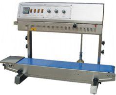 Máquina transportadora industrial con cinta azul y panel de control gris.