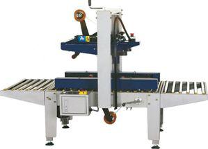 Máquina transportadora industrial con estructura azul y blanca, mesas de rodillos y conjunto vertical central.