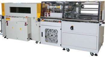 Máquina de embalaje industrial con armarios blancos, rodillos y paneles transparentes sobre ruedas.