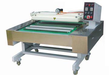 Máquina industrial con cinta transportadora verde y panel de control sobre una estructura metálica con ruedas.