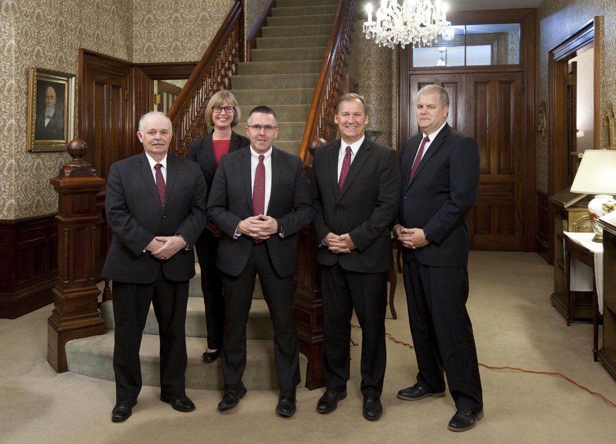 Funeral directors in a funeral home welcome visitors.