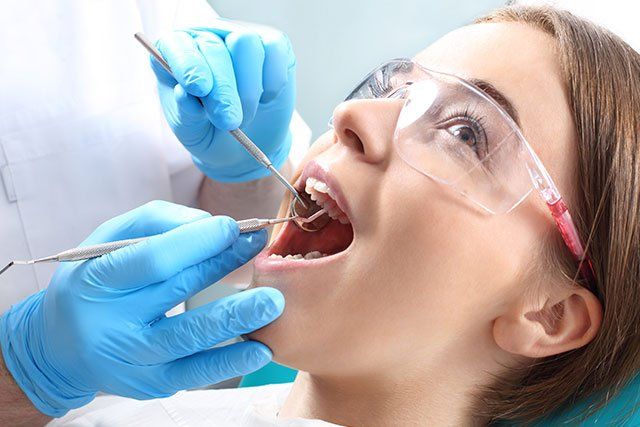 Implants — Hands Of The Dentist Checking The Mount Of Girl in MILWAUKEE, WE Implants — Hands Of The Dentist Checking The Mount Of Girl in MILWAUKEE, WE