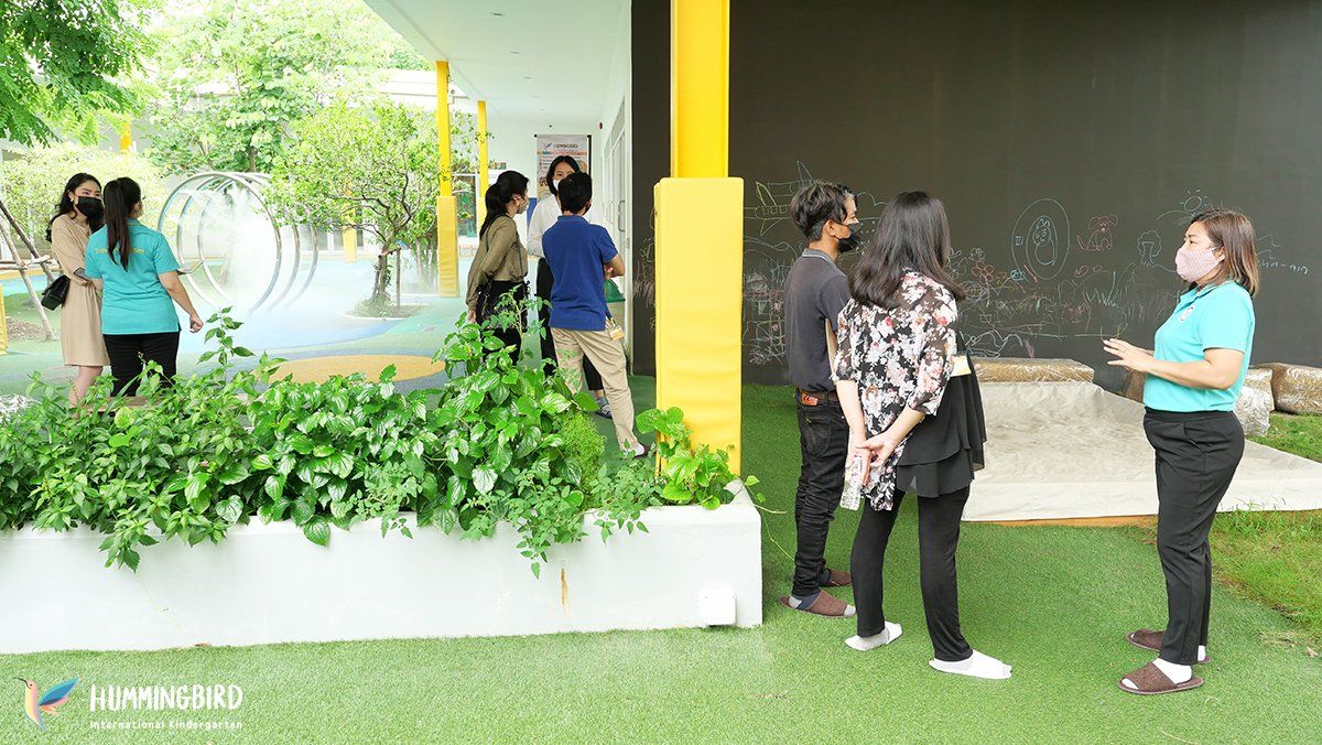 A group of people are standing next to each other on a lush green field.