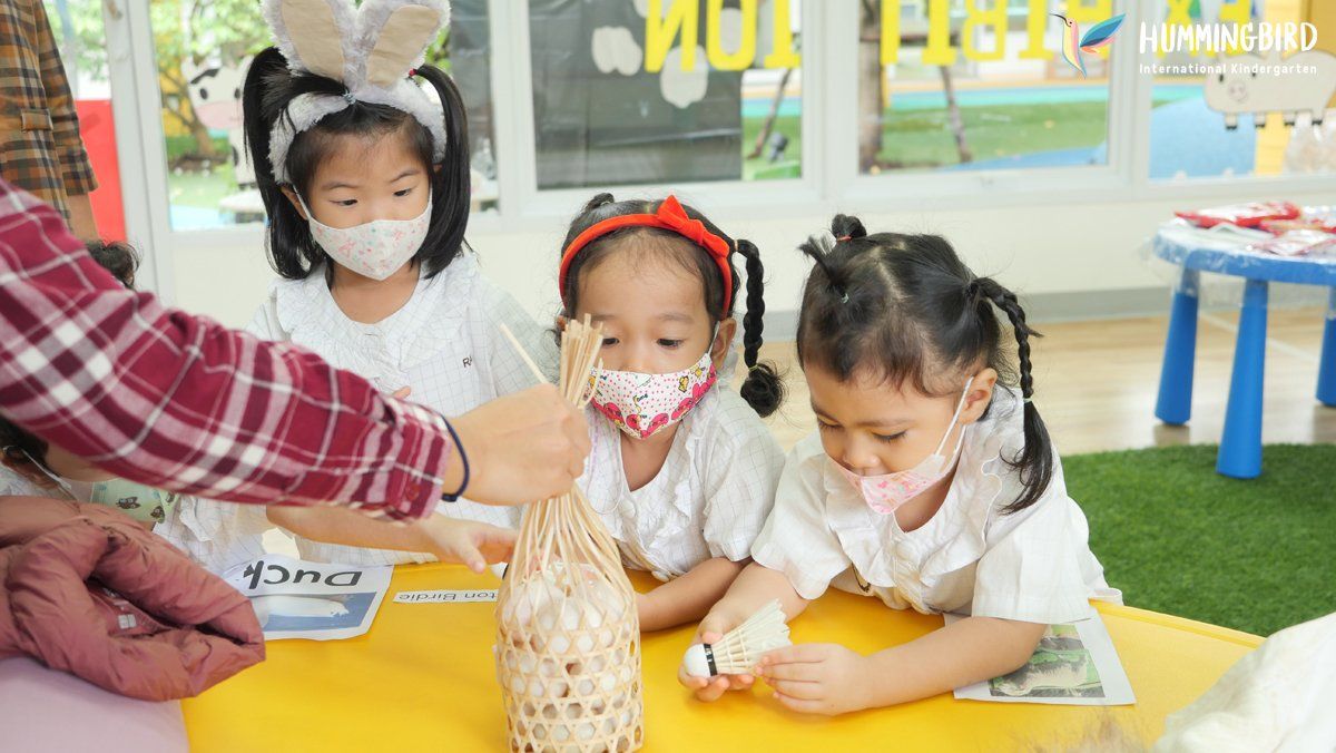 A group of young girls wearing face masks are sitting at a table.