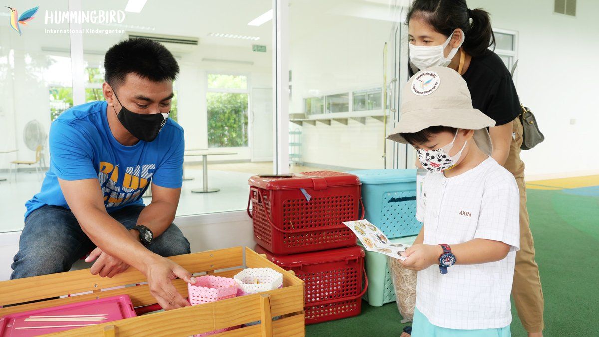 A man and a woman are standing next to a child wearing a mask.